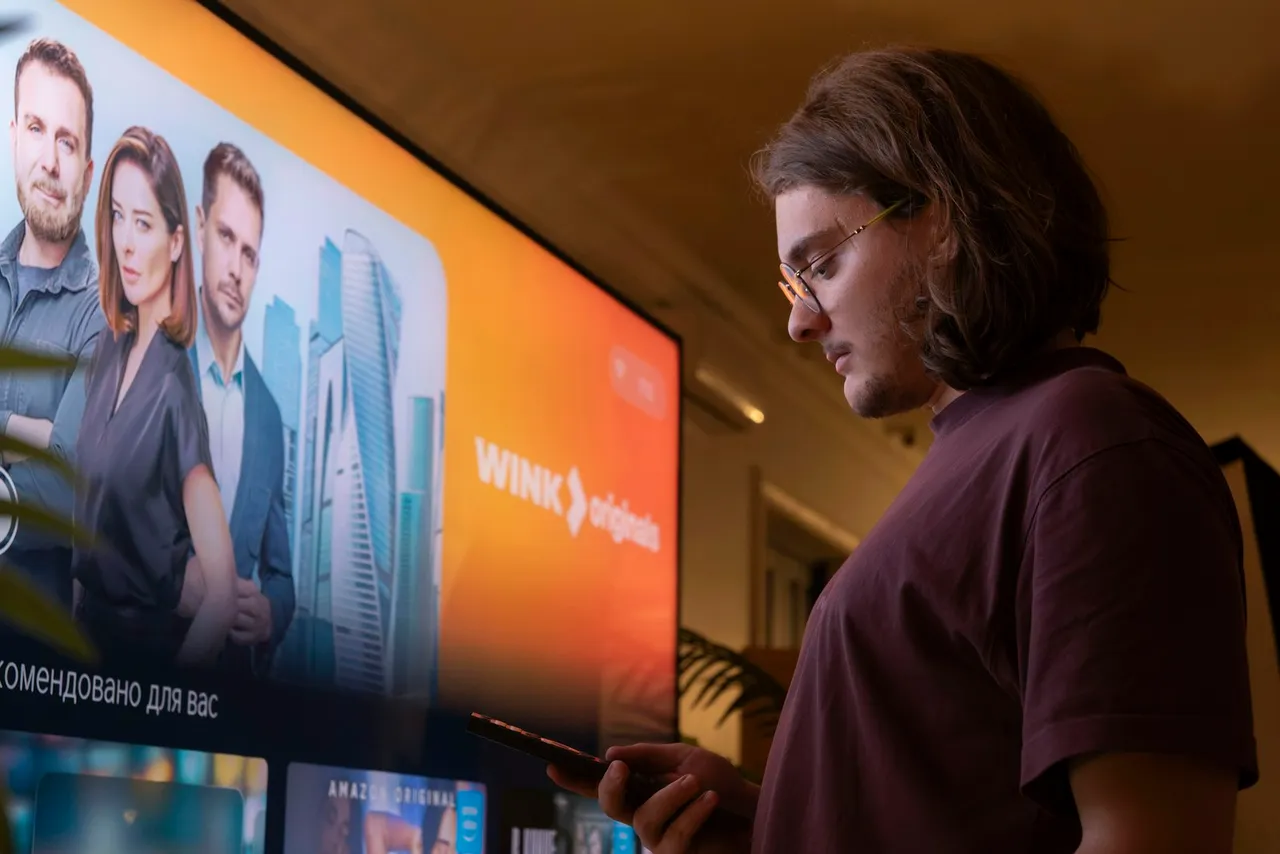 A viewer beside a large television