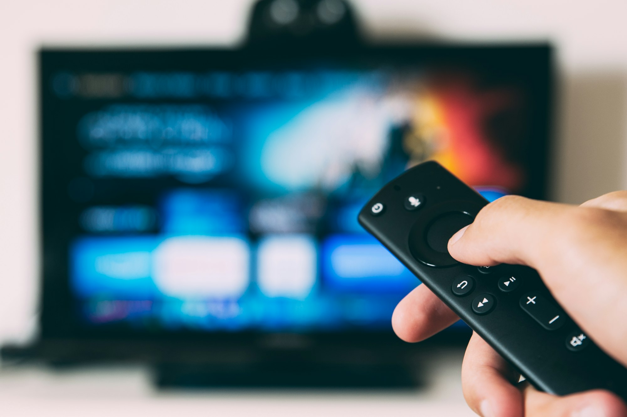 A smart TV streaming interface with a remote control in the foreground
